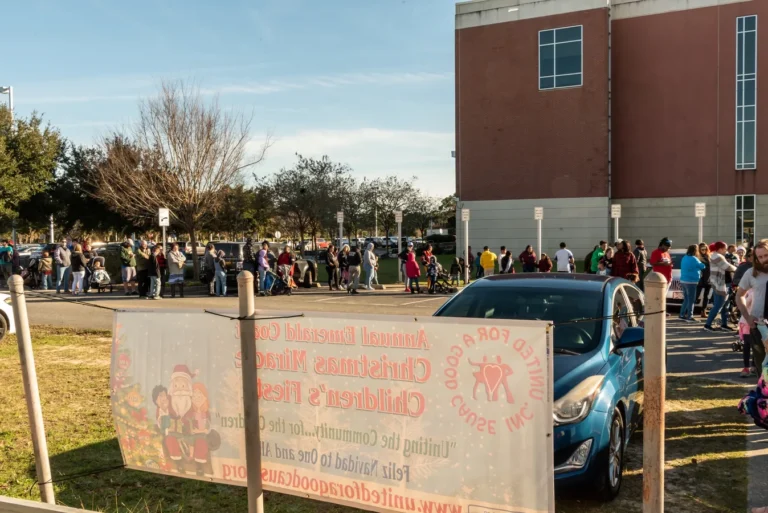 Families lined up outside for the Christmas Miracle Fiesta, next to the event banner