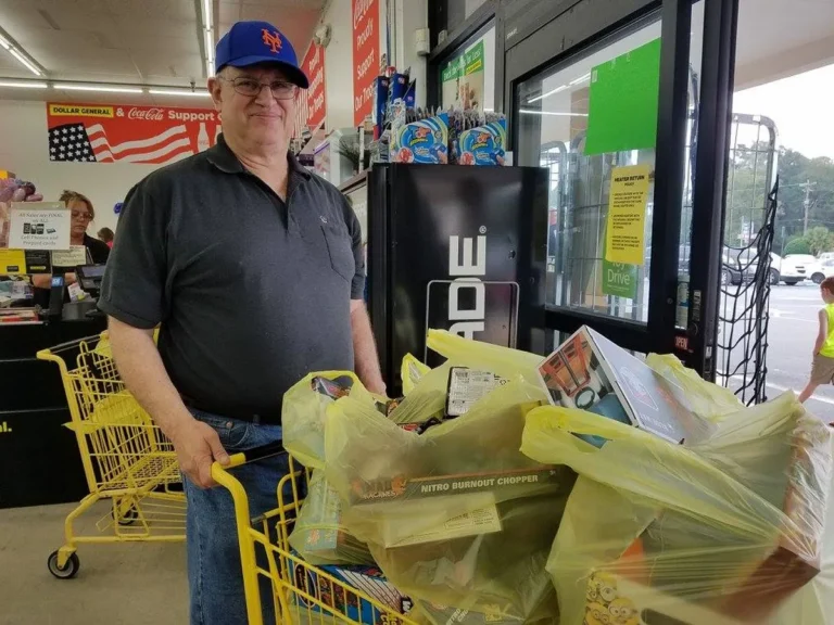A volunteer shopping for toys with a full cart
